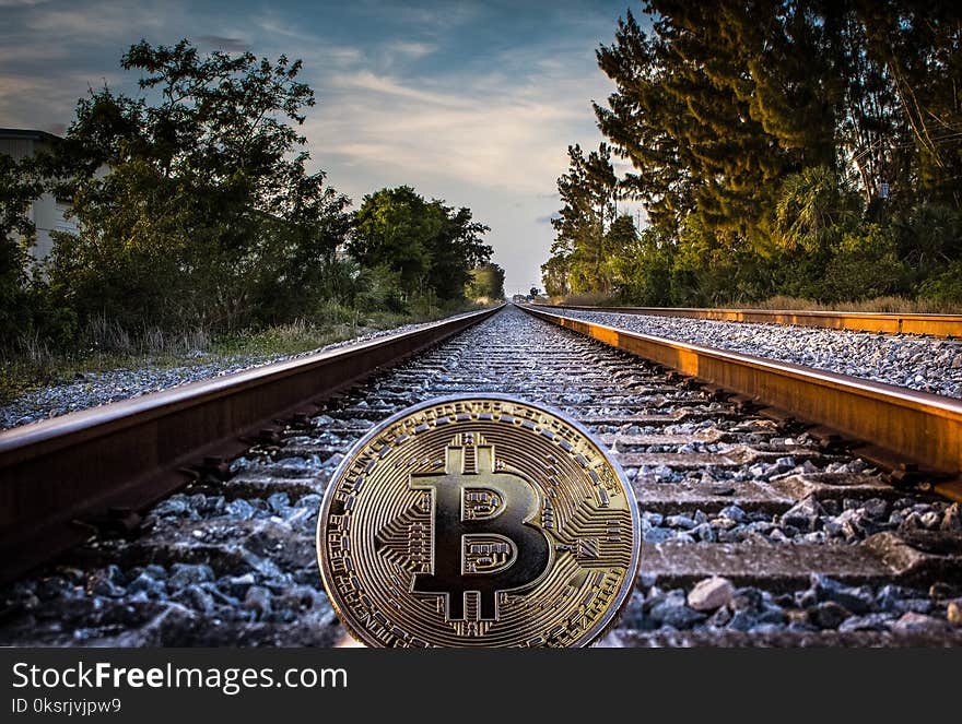 Gold-colored Bitcoin on Railroad