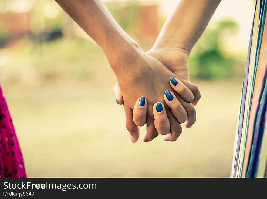 Shallow Focus Photography Of Two Person Holding Hands