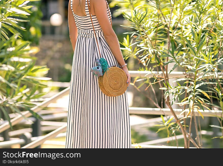 Woman Wearing White And Black Striped Sleeveless Maxi Dress