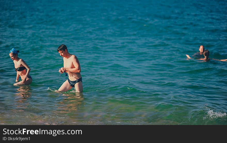 People Swimming On Body Of Water