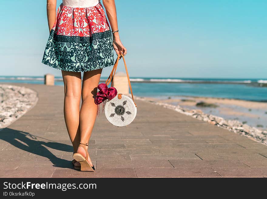 Woman Wearing Mini Skirt Holding Round Wicker Bag