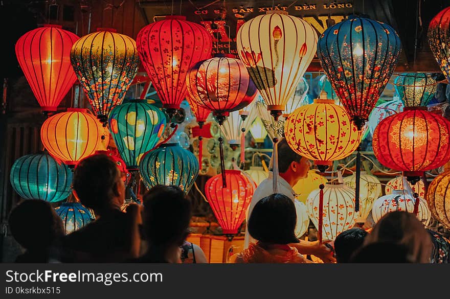 People Standing Near Assorted-color Lamps