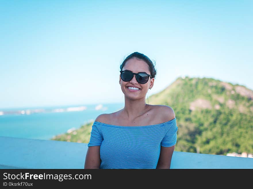 Smiling Woman Wearing Grey Striped Off-shoulder Top And Black Sunglasses