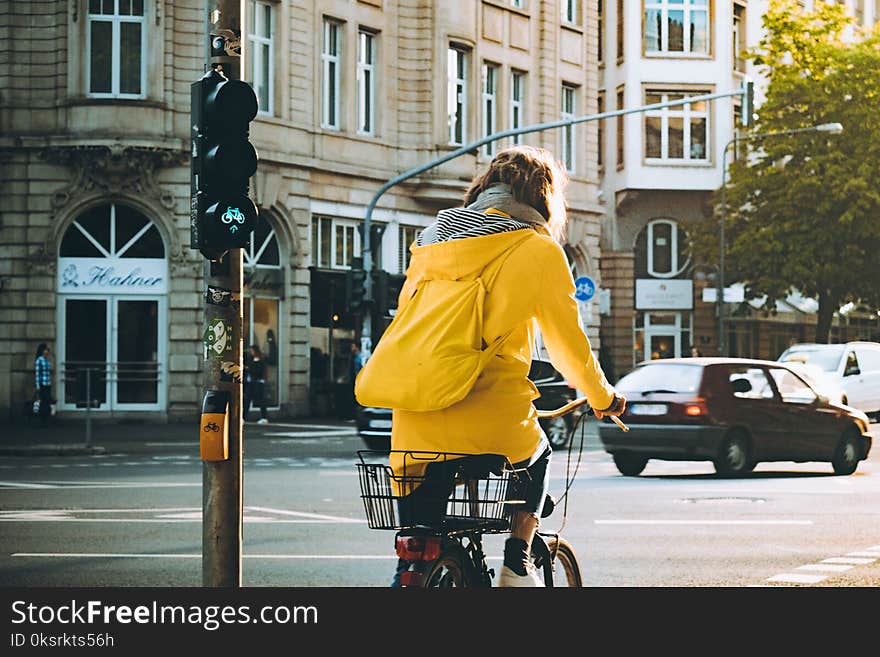 Woman Wearing Yellow Hooded Coat Riding Bicycle