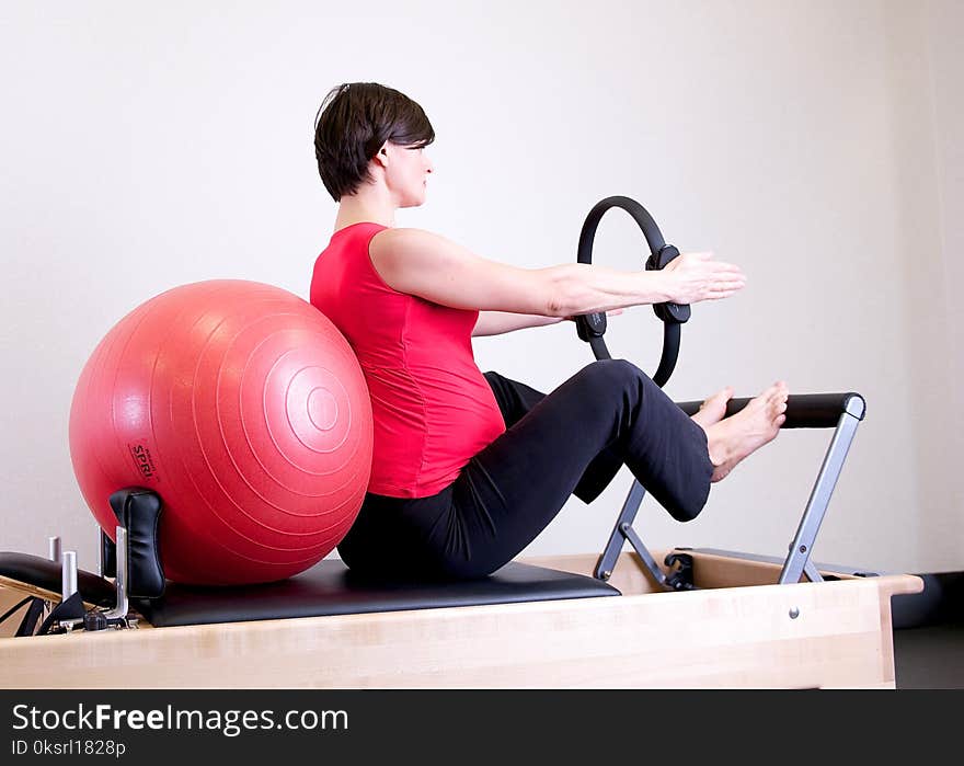 Woman in Red Top Leaning on Red Stability Ball