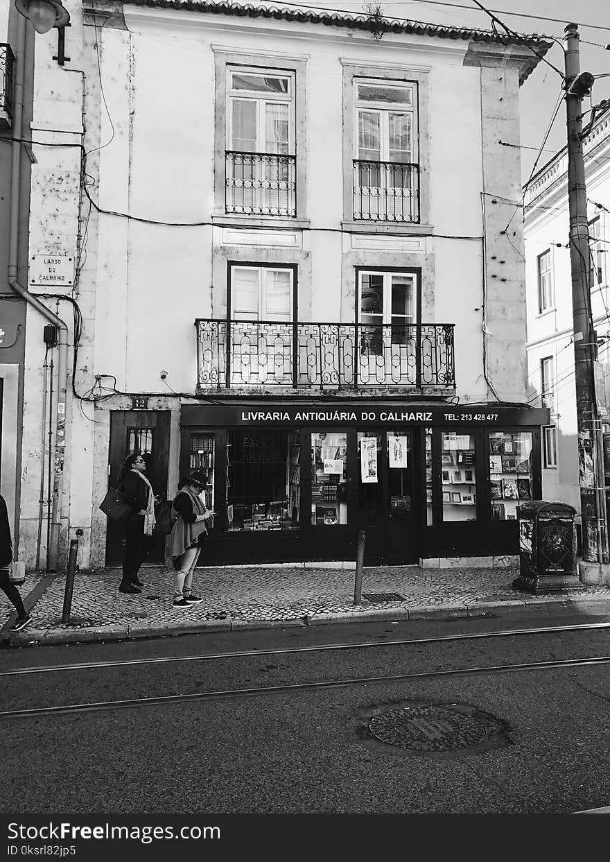 Grayscale Photography of Women Standing Near Building