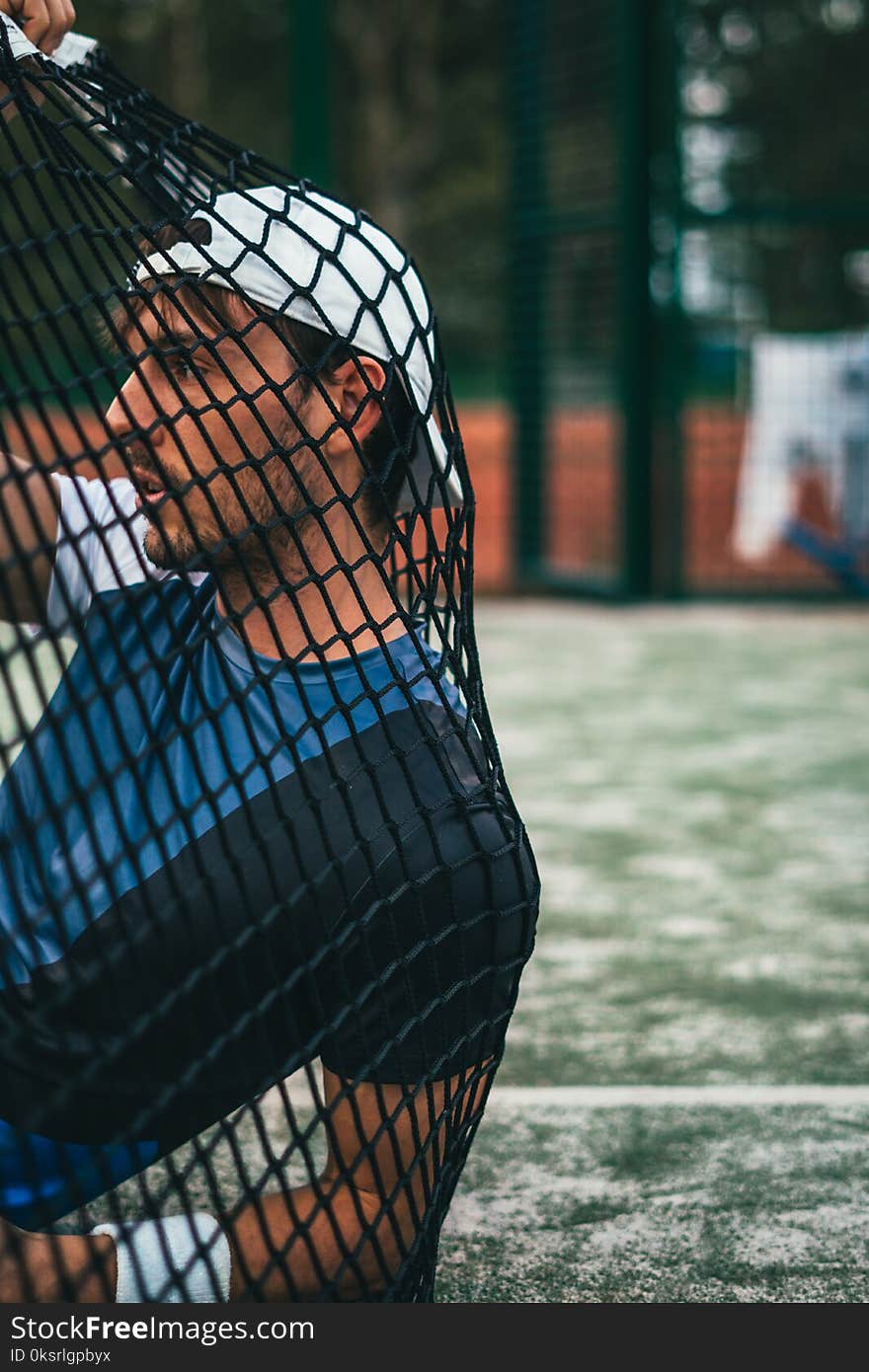 Person Sitting on Grass Holding Goal Net