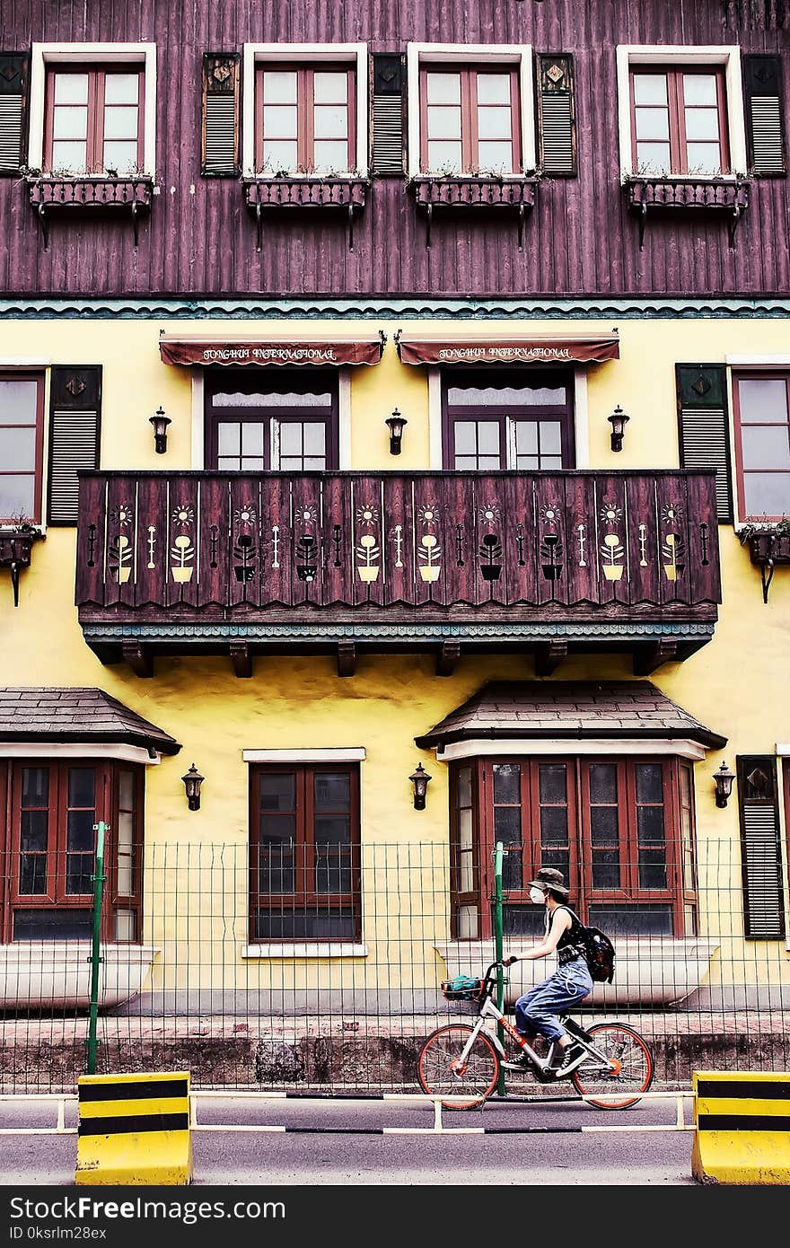 Woman Riding on Bicycle Near House