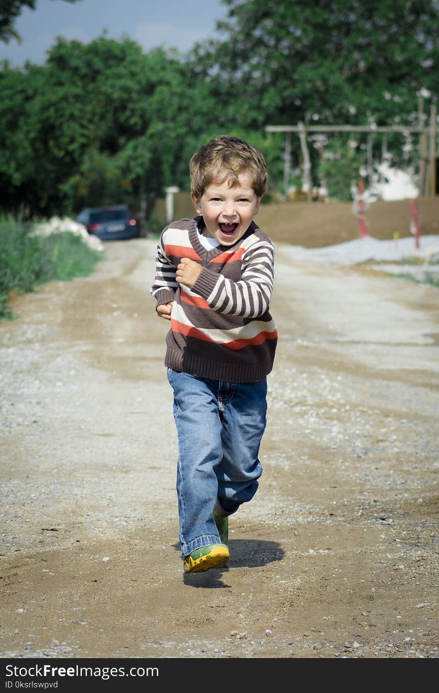 Boy Wearing Red, Brown, and White Stripe Sweater Running Photo