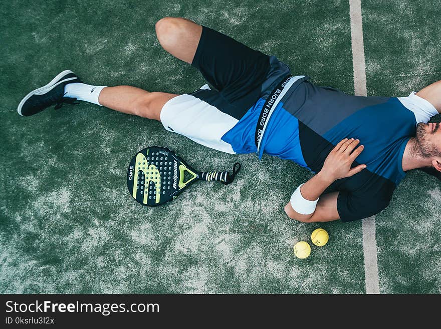 Man Lying Beside on Green Tennis Balls