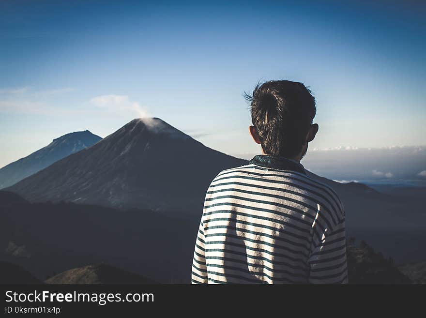 Man Wearing Striped Shirt Looking At Volcano