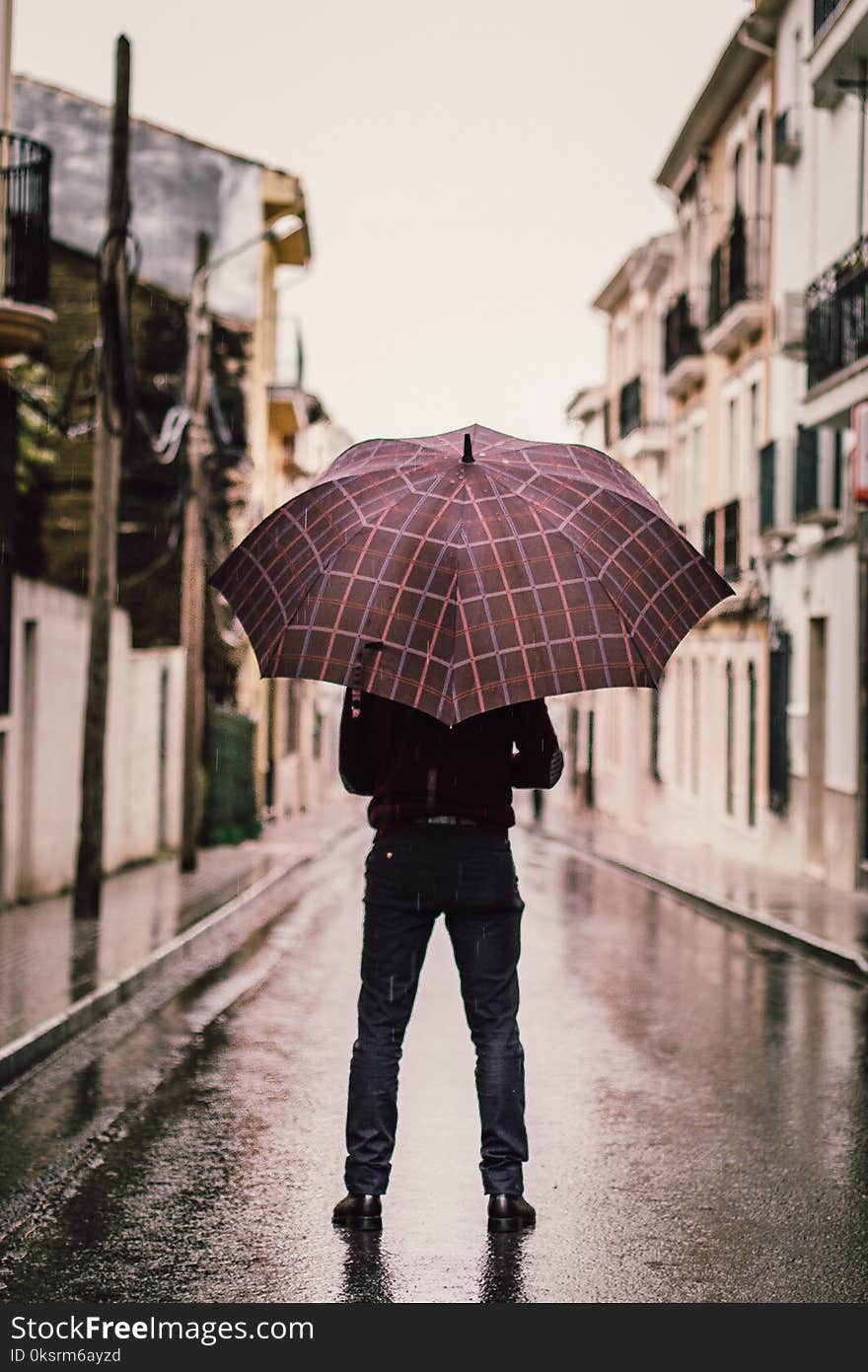 Person Wearing Black Pants Holding Umbrella Standing On Road