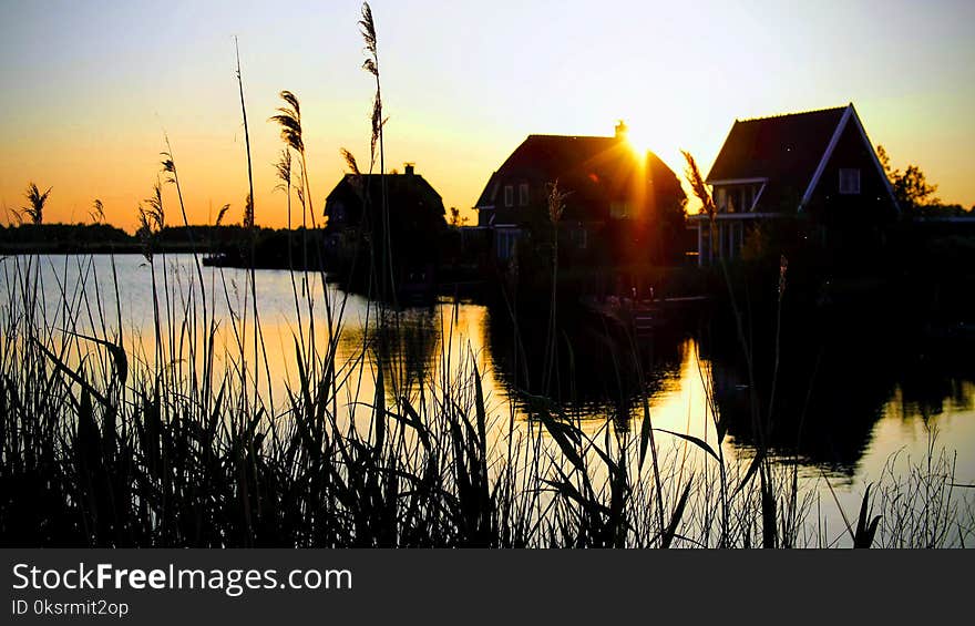 Silhouette Photograph of Houses Beside River