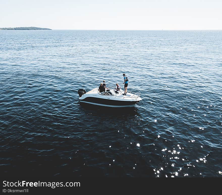 Three Person on White Motorboat at Daytime