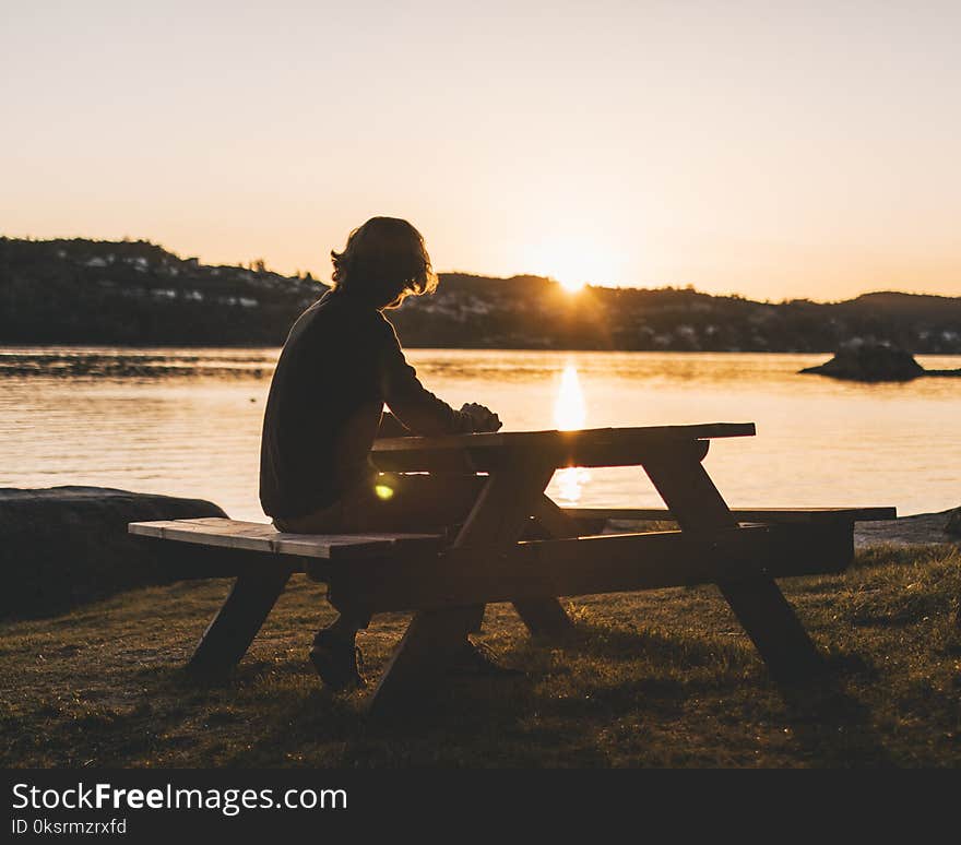 Silhouette of Persons Sitting on Picnic Table