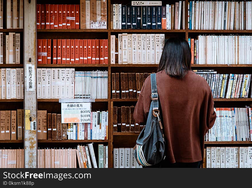 Woman Wearing Brown Shirt Carrying Black Leather Bag on Front of Library Books