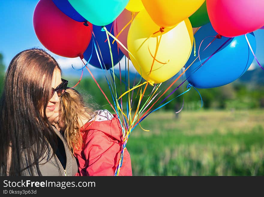 Happy child and mom playing with balloons outdoor. Kid having fun in spring field. Mother`s Day. Happy Mom and baby outdoor. Mother day. Children`s Day or Children Day