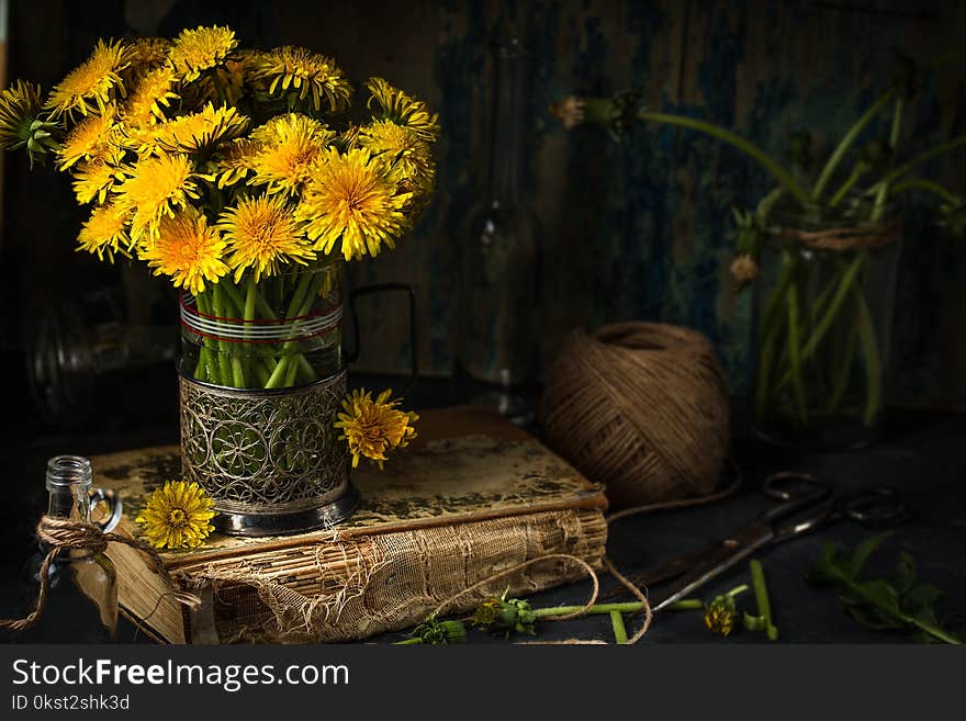 Dandelion flowers on rustic wooden background. Vintage still li