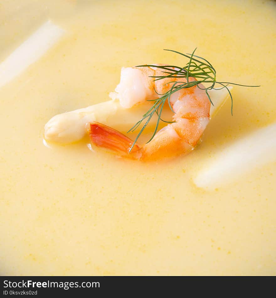 A delicious asparagus cream soup with prawns and fresh dill