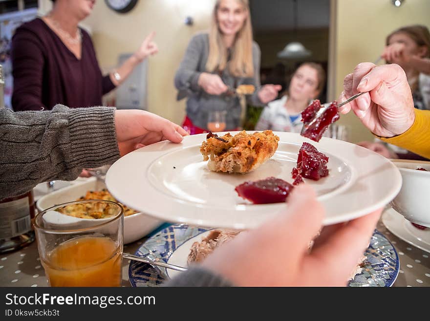 Close up shot of a plate getting cranberry sauce added to it by someone else at thanksgiving dinner. Close up shot of a plate getting cranberry sauce added to it by someone else at thanksgiving dinner.