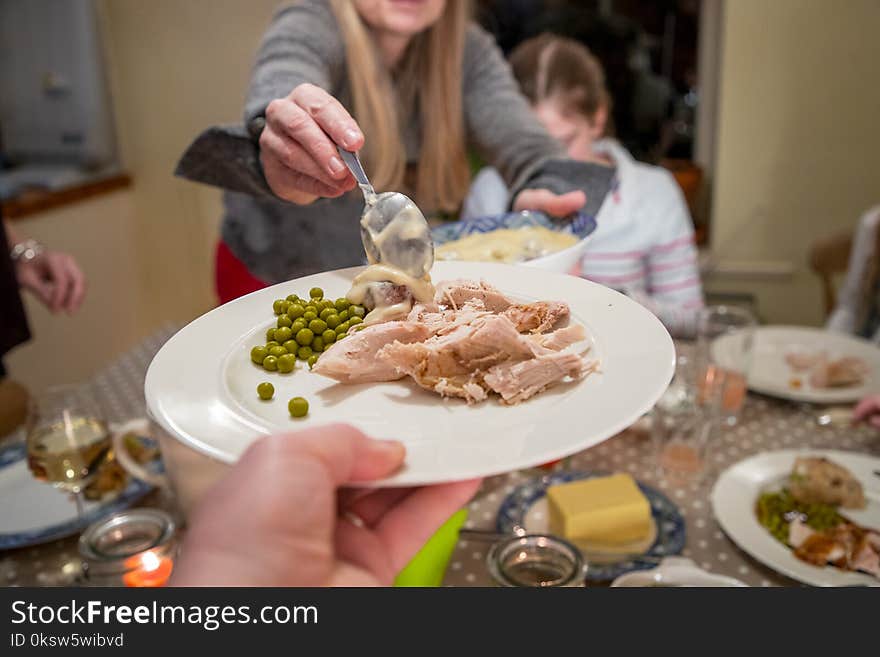 Woman serves food to her family for Thanksgiving. Woman serves food to her family for Thanksgiving.