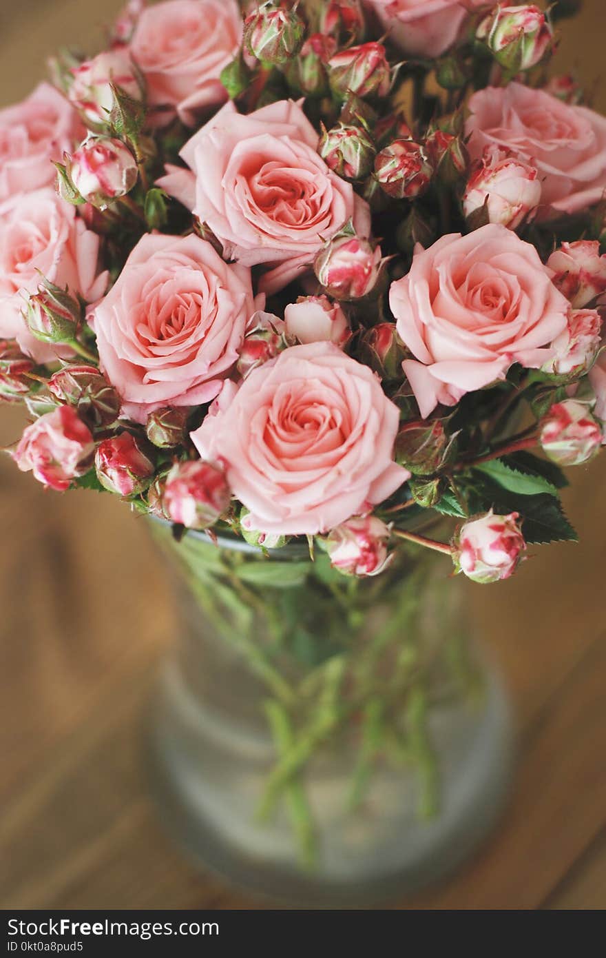 Pink roses bouquet over wooden table. Top view with copy space. Toned. Pink roses bouquet over wooden table. Top view with copy space. Toned