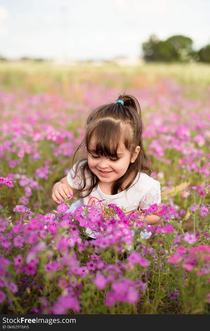 Little happy girl in a purple flower field