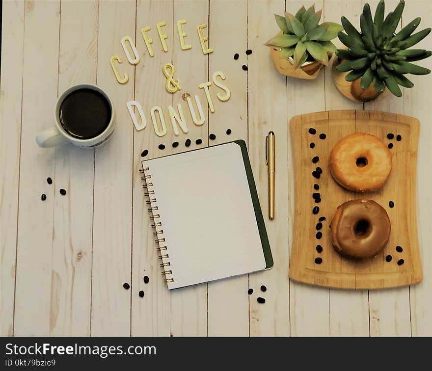 Spiral Notebook Beside Pen and Plants