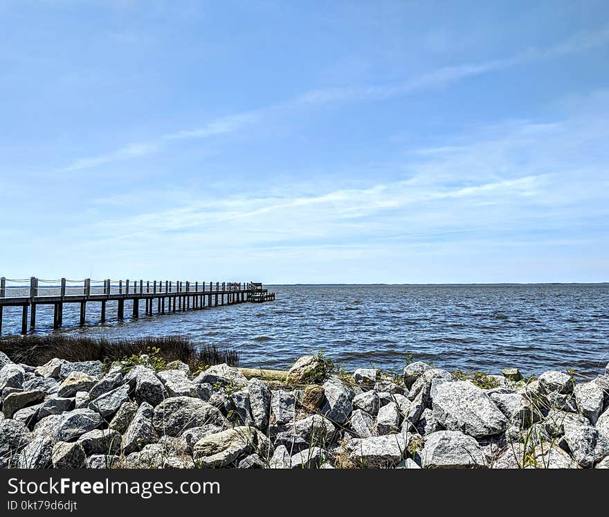 Brown Wooden Dock Near Gray Rocks