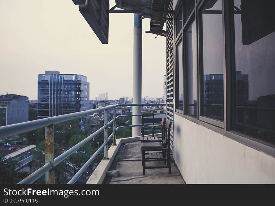 Two Wooden Chairs on Terrace of Building