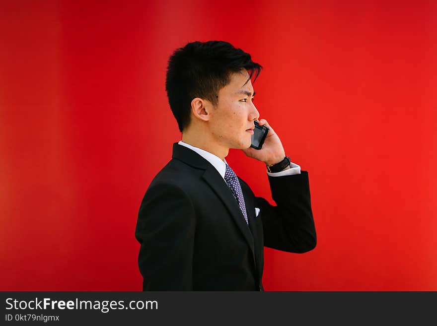 Man Holding Smartphone Wearing Black Notched-lapel Suit Jacket