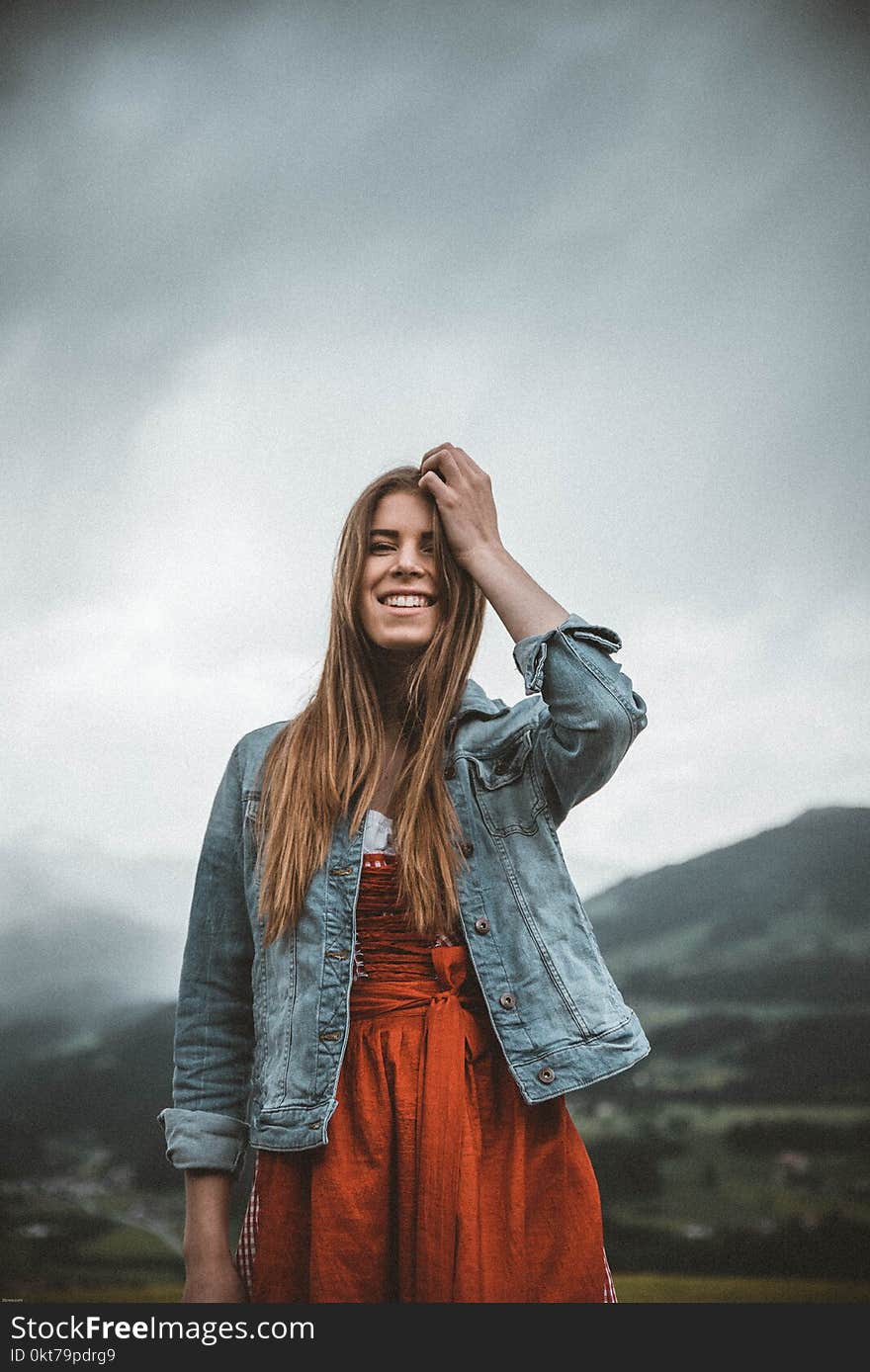 Woman Wearing Blue Denim Button-up Jacket Under Heavy Clouds