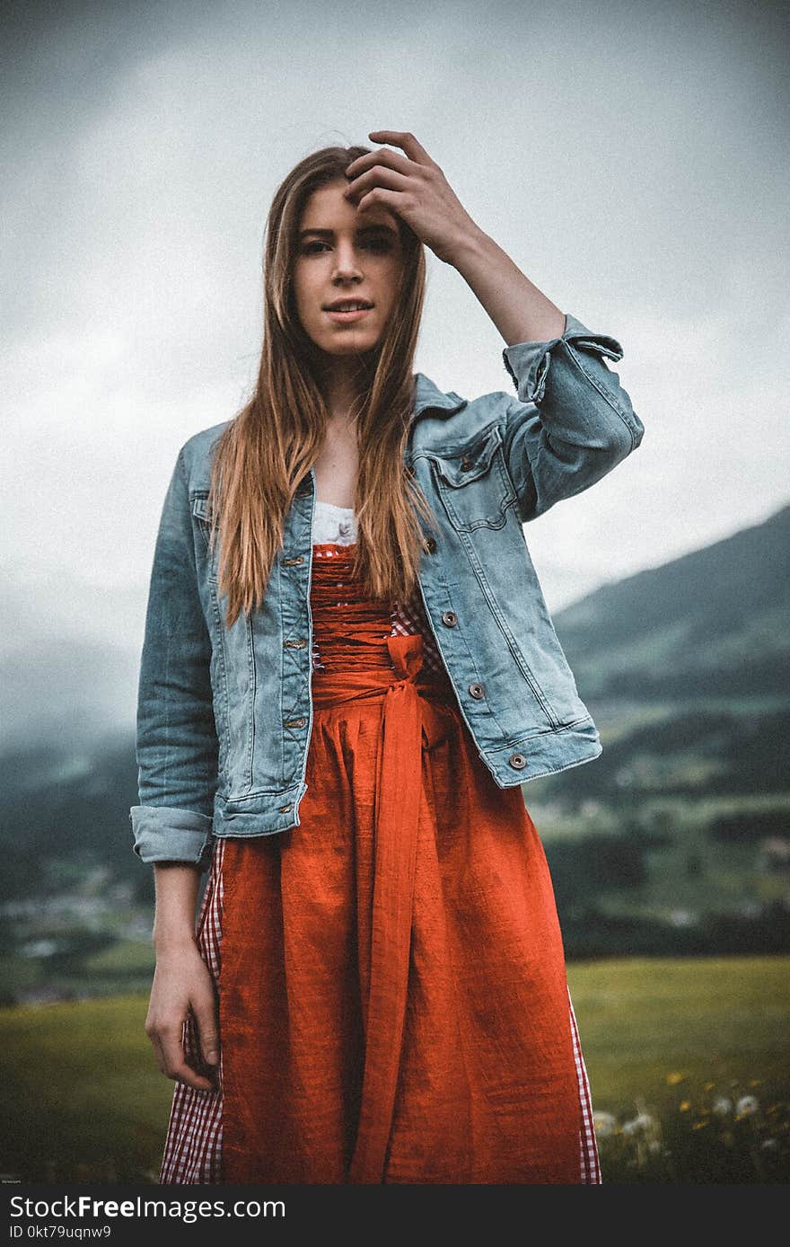 Woman in Blue Denim Button-up Jacket Behind Green Grass Field