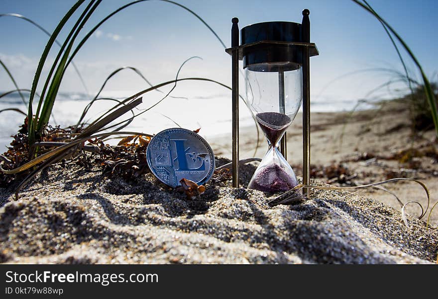 Clear Hour Glass on Brown Sand