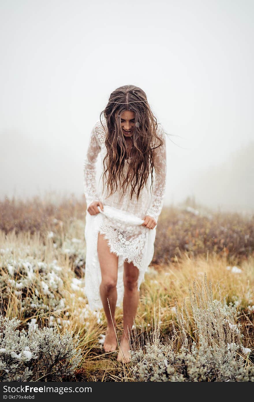 Woman Wearing White Lace Long-sleeved Dress Walking on Grass