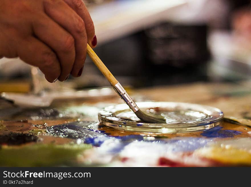 Person Holding Brown and Gray Paint Brush