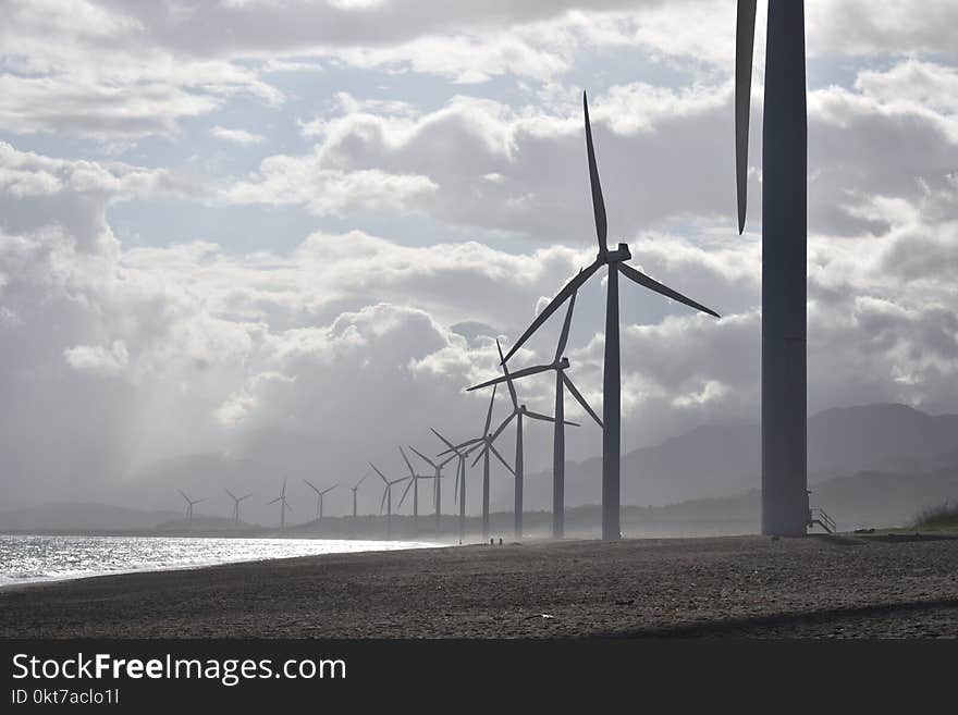 Windmills on Seashore Under White Clouds