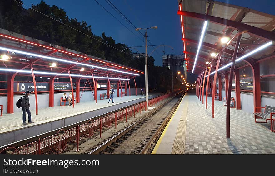 Man Waiting on Train Platform during Nighttime