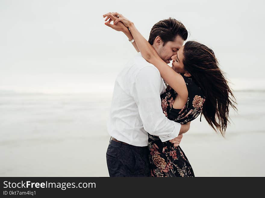 Man and Woman Hugging Each Other Near Body of Water