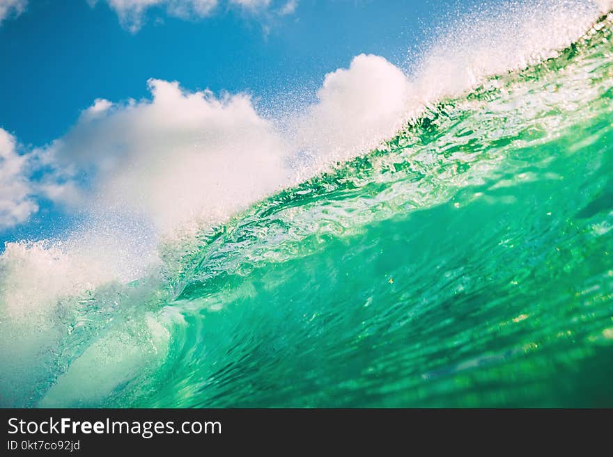 Crystal green wave in ocean. Breaking wave and evening light