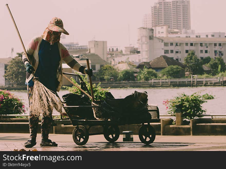 Person Holding Broom And Cart