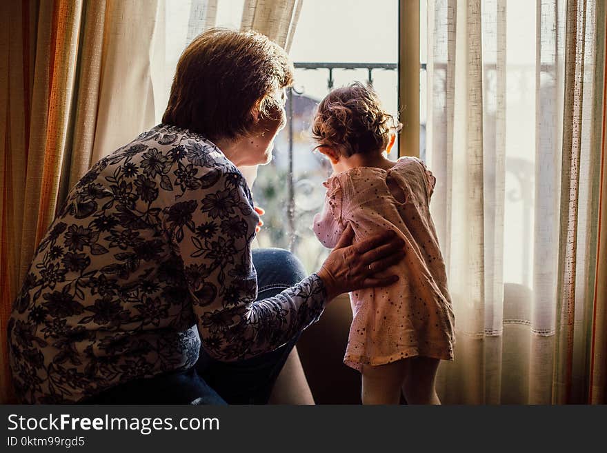 Woman Holding Baby Near Window