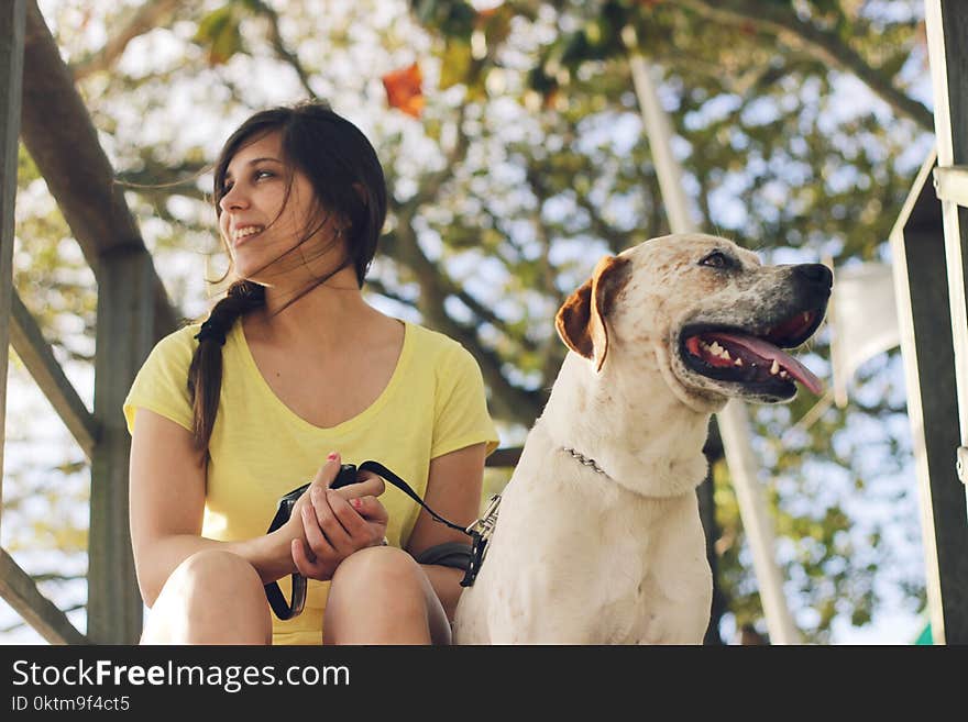 Woman Wearing Yellow V-neck T-shirt Beside Short-coated White and Brown Dog at Daytime