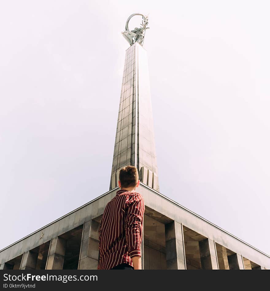 Man Standing in Front of Gray Concrete Tower