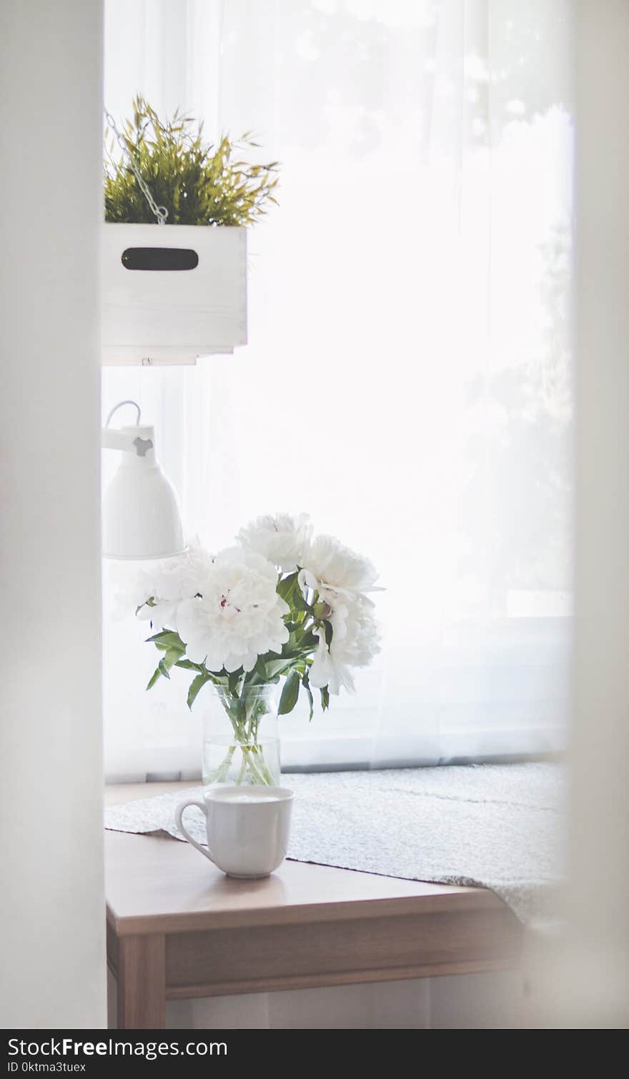 White Peonies in Clear Glass Vase Centerpiece Near a White Ceramic Mug Closeup Photography