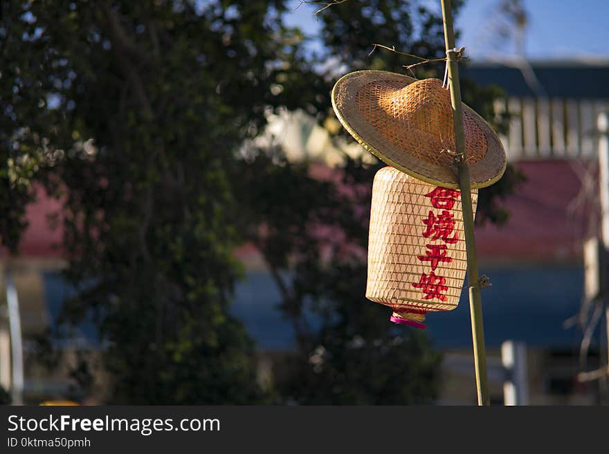 Straw Hat And Paper Lantern Placed On Bamboo Pole