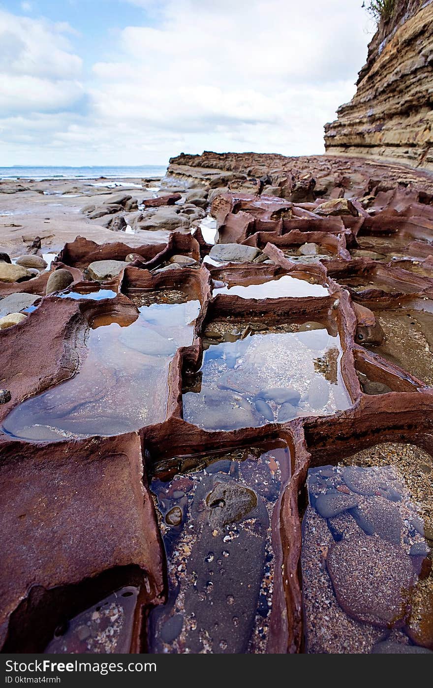 Calm Body of Water Beside Rocks