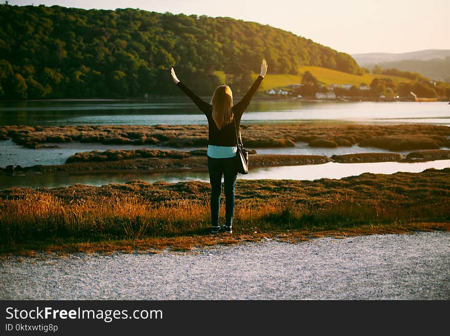 Woman Wearing Black Jacket Standing on Grass Field