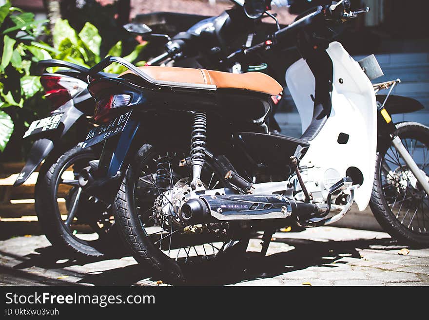 White Underbone Motorcycle Parked Beside a Motorcycle