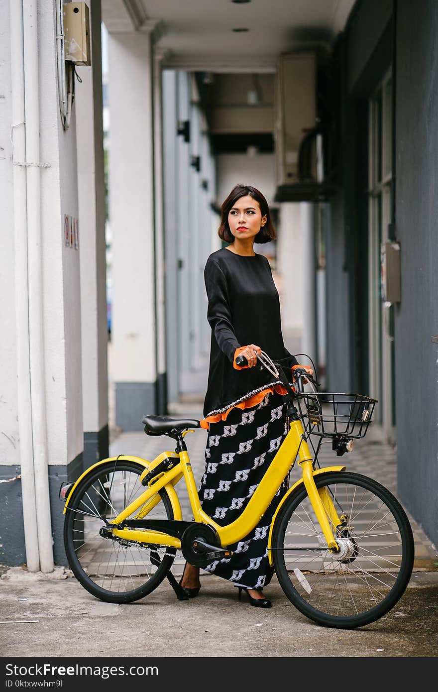 Woman Holding Yellow Bike at Daytime